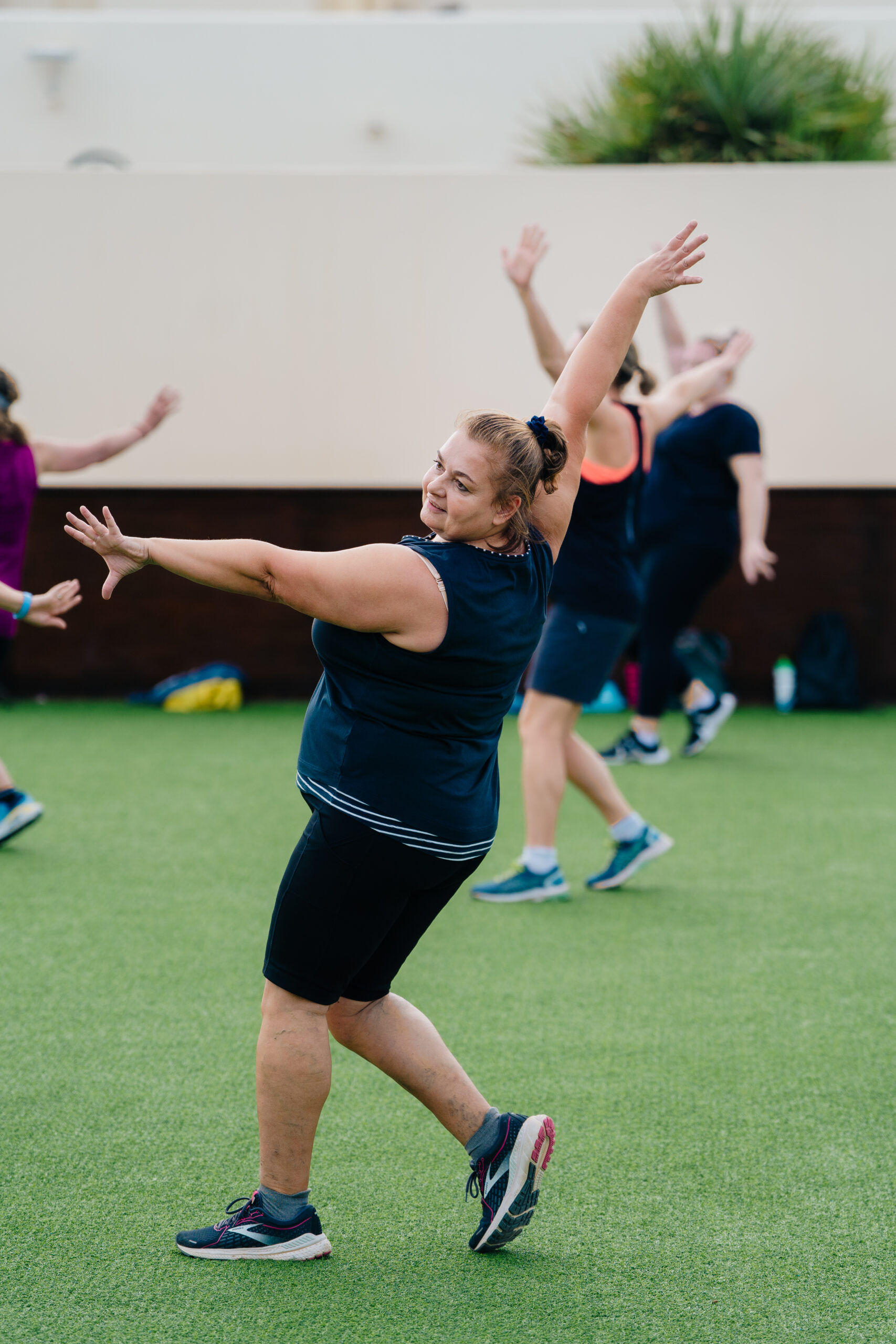 A woman wearing black activewear dancing in a Zumba class