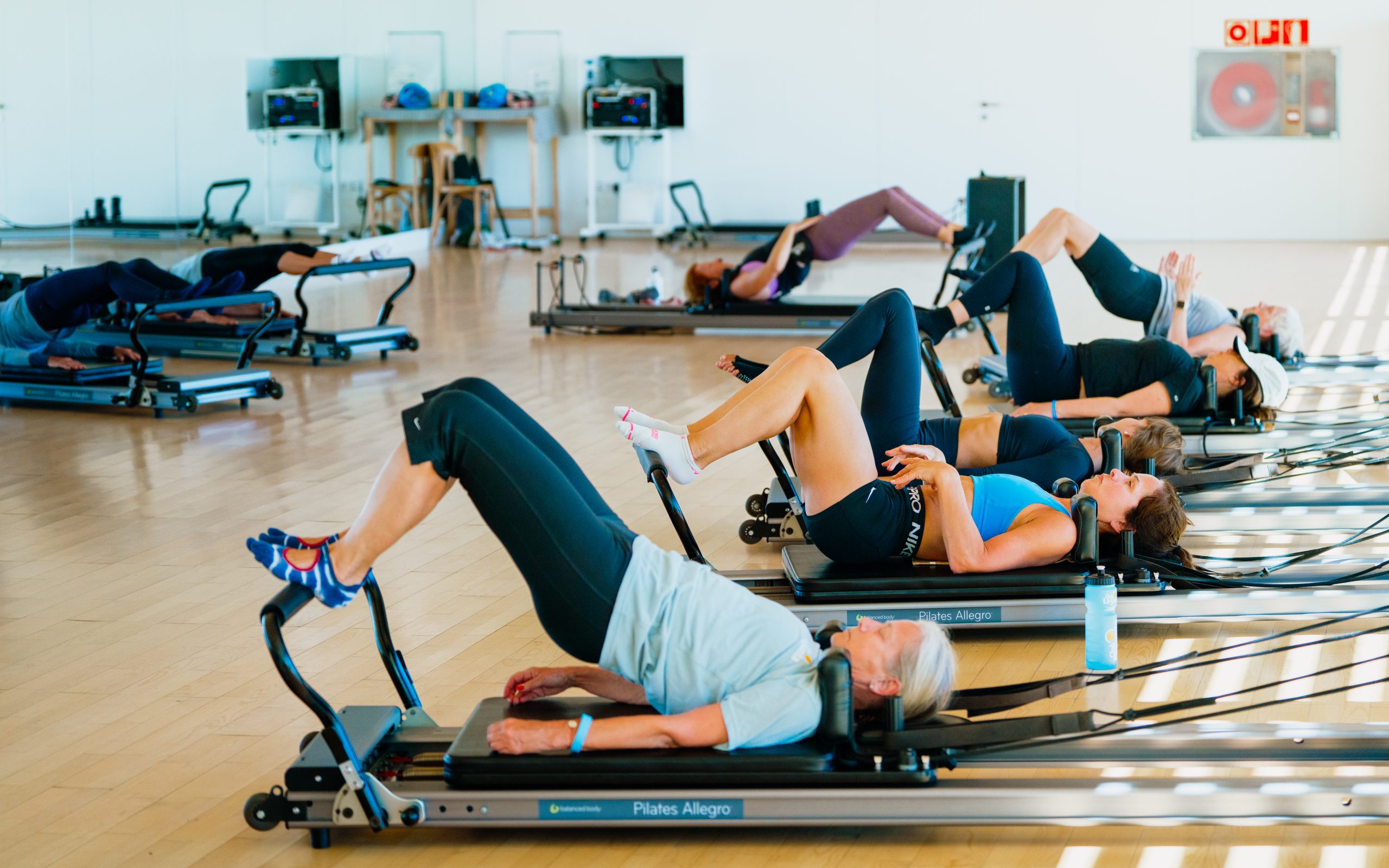 A group of adults in a reformer pilates class at Club La Santa