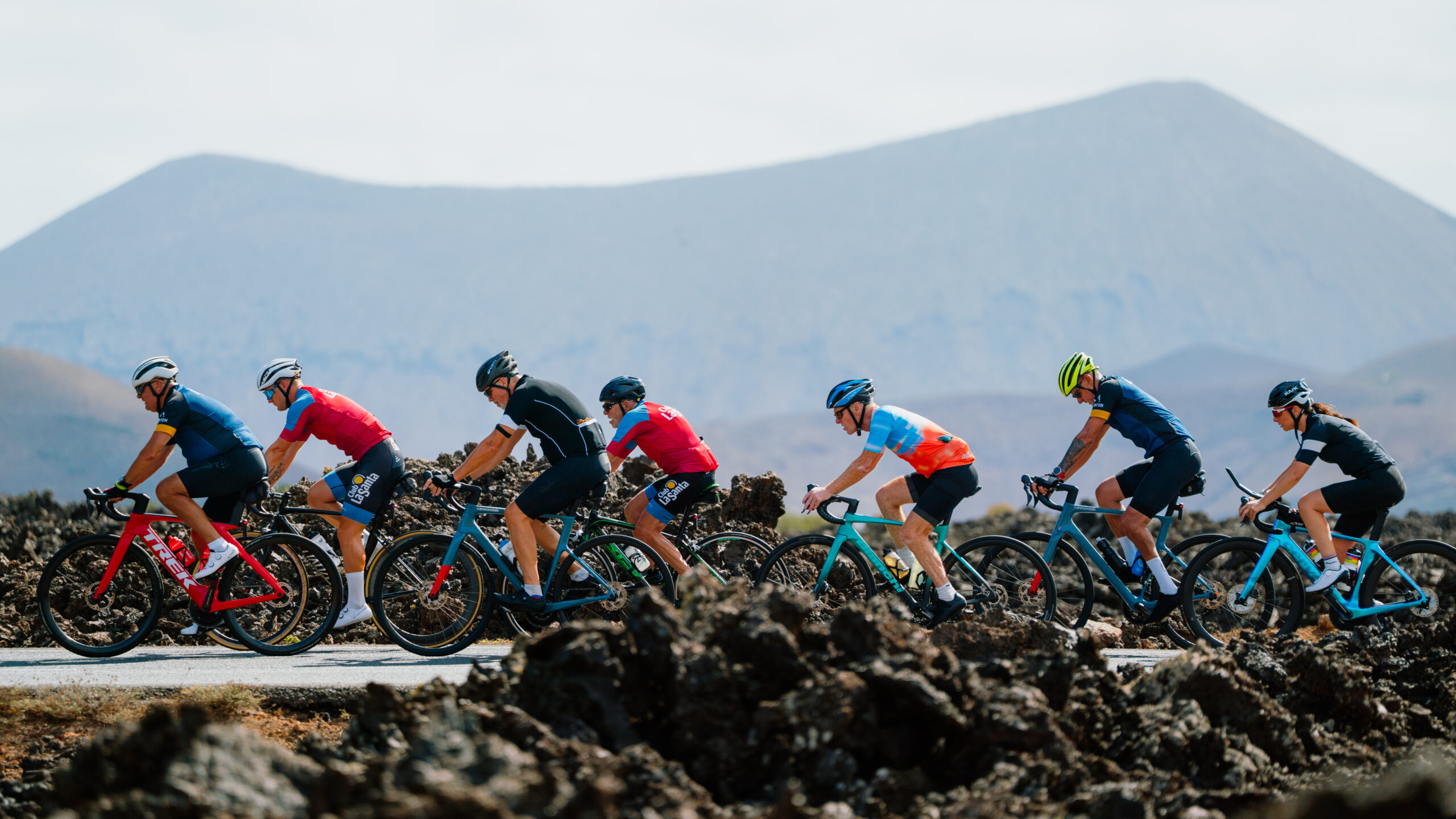 A group of cyclists wearing helmets and cycling-suit, cycling in the mountains surrounding Club La Santa.