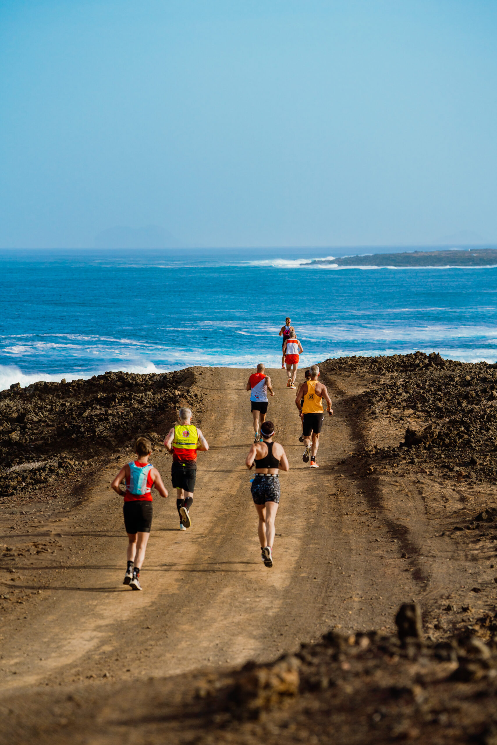 Runners participating in a trail run along a dirt path near the coast at Club La Santa, Lanzarote - 2