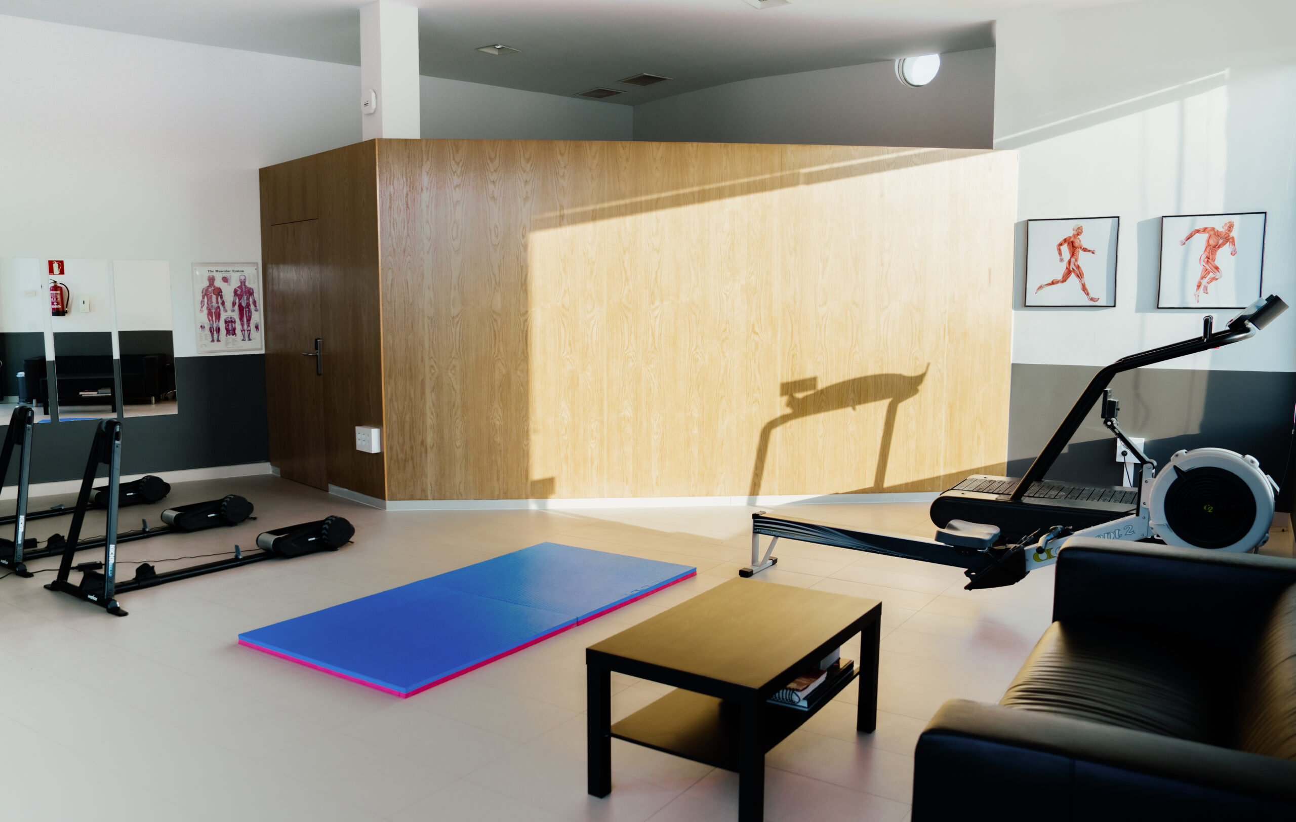 The Sports Performance Studio at Club La Santa, featuring static bike stands for bike fits, a treadmill, rowing machine and yoga mat.