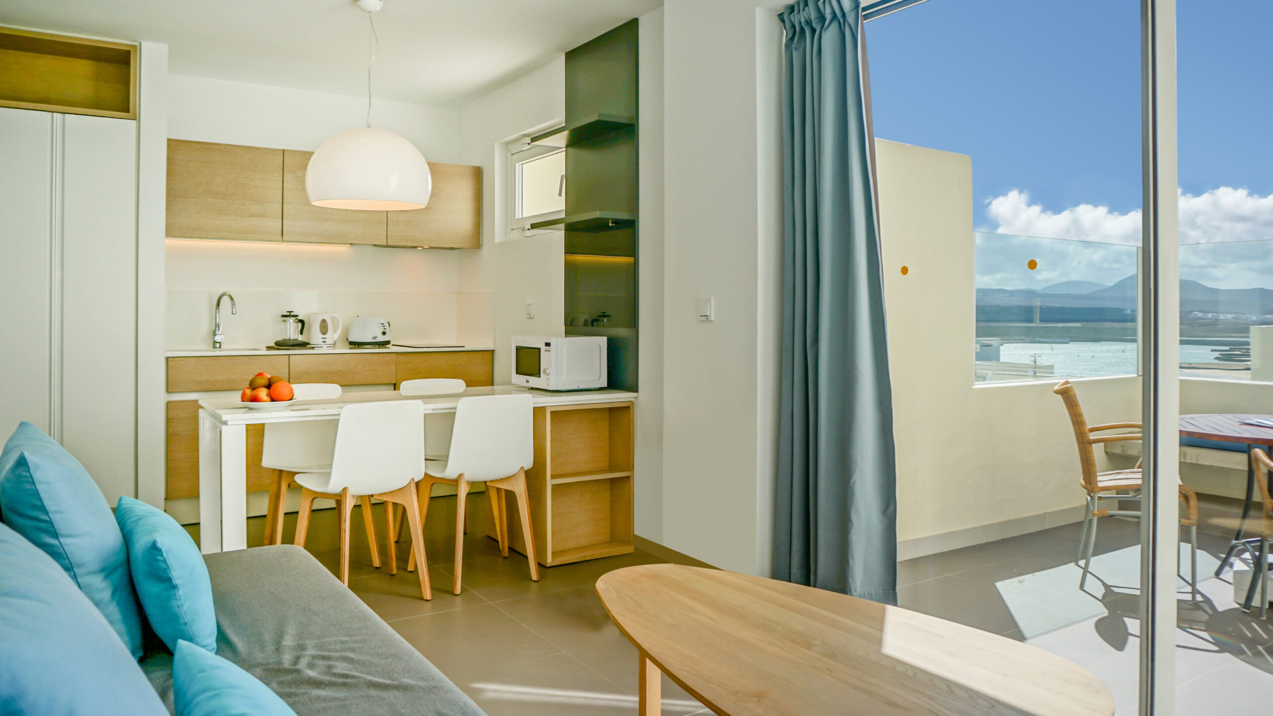 Image of Comfort 1 Bedroom 1 Bathroom apartment with view, showing the kitchen and view through the balcony doors.